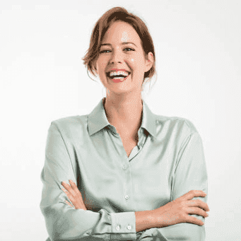 Goldankauf Johannsson Bewertung Profilbild Frau in heller Bluse mit zurueckgesteckten Haaren Arme verschraenkt lachend - Monika Schneider